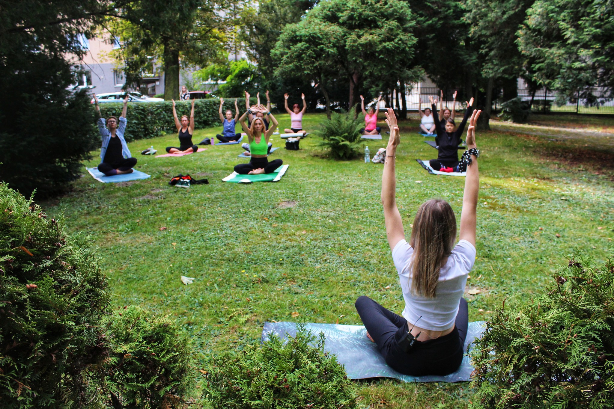 Fotografia. Uczestniczki zajęć jogi w otoczeniu zieleni.